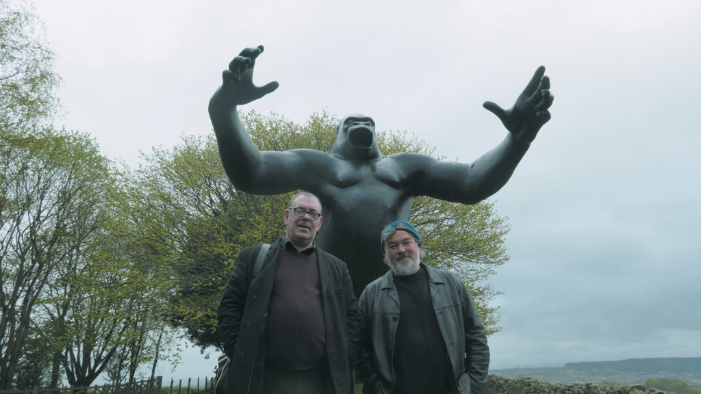 The musician Robert Lloyd and the comedian Stewart Lee in front of Nicholas Monro’s sculpture of King Kong, Cumbria, England; from King Rocker